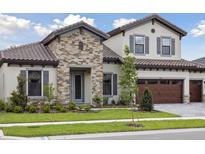 Charming two-story home featuring a stone facade, well-maintained landscaping, and a three-car garage at 14531 Swiss Bridge Dr, Lithia, FL 33547