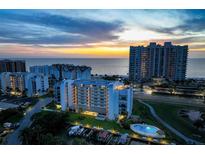Stunning aerial view of the condo complex at sunset, featuring a pool and waterfront access at 1581 Gulf Blvd # 701N, Clearwater Beach, FL 33767