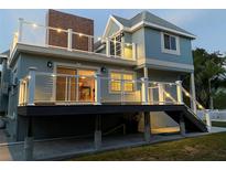 Stunning elevated back deck featuring modern railings, overhead lighting, and steps down to a well-kept backyard at 160 Shore Dr, Palm Harbor, FL 34683