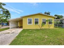 Charming yellow single-story home with a carport and a well-maintained lawn at 1903 24Th St, Sarasota, FL 34234