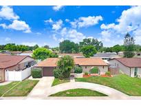 Charming single-story home featuring a circular driveway, arched entryway, and well-maintained landscaping at 2119 Sugarbush Dr, Holiday, FL 34690