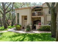 Charming townhouse featuring a private balcony, manicured lawn and brick-paved walkway to the front door at 247 Los Prados Dr # 1123, Safety Harbor, FL 34695