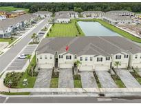 A beautiful aerial view of these townhomes near a body of water within a well-manicured community at 26082 Woven Wicker Bnd, Lutz, FL 33559