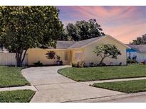 Charming one-story home with a well-manicured lawn and mature tree at 310 Arbor E Dr, Palm Harbor, FL 34683