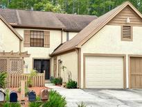 Beige two-story townhome with two car garage, shuttered windows and tidy landscaping at 4006 Huxford Ct, Tampa, FL 33624
