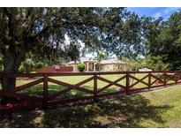 Charming single-story home with well-maintained lawn and decorative wooden fence at 408 River Bed Ct, Wimauma, FL 33598