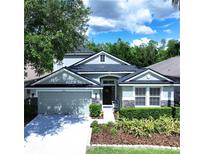 Charming two-story home with a well-manicured lawn, a two car garage, and a welcoming front porch at 4116 Knollpoint Dr, Wesley Chapel, FL 33544