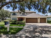 Charming two-story home featuring a three-car garage, lush landscaping, and a well-manicured lawn at 5315 Cedarshake Ln, Valrico, FL 33596