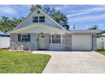 Charming one-story home with stone accents, a garage and a well-manicured lawn at 8074 37Th N Ave, St Petersburg, FL 33710