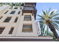 Beautiful condo building exterior with balconies, blue sky, and palm trees at 100 4Th S Ave # 103, St Petersburg, FL 33701