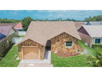 Charming single-story home featuring a stone facade, well-manicured lawn, and attached garage at 1331 Coolmont Dr, Brandon, FL 33511