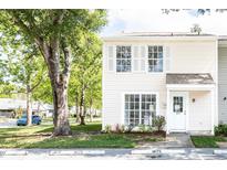 Charming two-story condo featuring white siding, white trimmed windows, and landscaped yard at 16175 Rambling Vine E Dr, Tampa, FL 33624