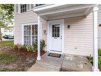 Inviting front entrance features a classic white door, covered porch, and a 'Welcome' mat, enhancing the curb appeal at 16175 Rambling Vine E Dr, Tampa, FL 33624