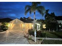 Night view of a single-Gathering home with well-maintained landscaping and a three-car garage at 2810 Ravendale Ln, Holiday, FL 34691