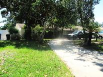 Charming single-story home with a well-manicured lawn and mature trees lining the driveway at 5468 26Th N Ave, St Petersburg, FL 33710