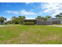 Charming single-story home featuring a large front yard with a screened in porch at 11896 104Th Ln, Largo, FL 33773