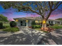 Charming home with a driveway, manicured lawn, and mature landscaping beneath a beautiful, large tree at 1214 Haddington Cir # 1214, Sun City Center, FL 33573