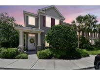 Charming two-story home features a well-manicured lawn and inviting entrance at sunset at 12472 Country White Cir, Tampa, FL 33635