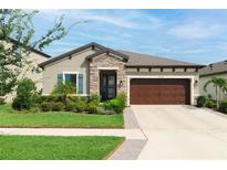 Charming single-story home featuring stone accents, manicured landscaping, and a two-car garage at 12643 Shetland Walk Dr, Lithia, FL 33547