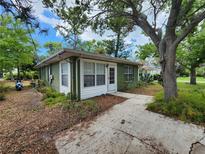 Green home exterior featuring a walkway, white trim, and lush landscaping at 159 6Th Nw St, Largo, FL 33770
