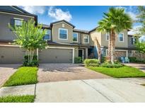 Charming townhome with well-maintained landscaping, brick paved driveway, and attached two-car garage at 28504 Tranquil Lake Cir, Wesley Chapel, FL 33543