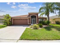 Charming single-story home featuring a well-maintained lawn and an attached two-car garage at 31244 Baclan Dr, Wesley Chapel, FL 33545