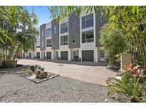 Modern townhome exteriors with gray and white facade, dark garage doors, and meticulously landscaped grounds at 325 5Th S Ave # 9, St Petersburg, FL 33701