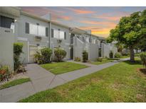 Charming condo complex with lush lawn, sidewalk, and stairs leading to the entrance at 4130 Dolphin Dr, Tampa, FL 33617