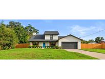 Charming two-story home with well-maintained lawn, a blue front door, and an attached garage at 5303 Glen Harwell Rd, Plant City, FL 33566