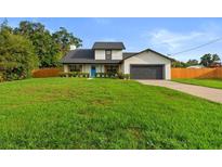 Charming two-story home with a well-manicured lawn, attached garage, and inviting blue front door at 5303 Glen Harwell Rd, Plant City, FL 33566