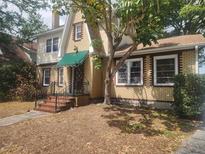 Charming brick home featuring a peaked roof, multiple windows, and a lovely tree in the front yard at 535 22Nd N Ave, St Petersburg, FL 33704