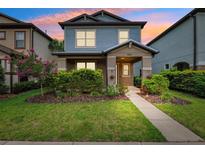 Charming two-story home showcasing a covered porch, manicured lawn, and vibrant landscaping at 5831 Caldera Ridge Dr, Lithia, FL 33547
