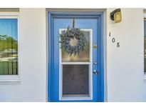 Blue front door features a storm door with a wreath and house number at 8080 112Th St # 108, Seminole, FL 33772