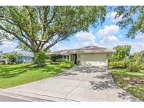Charming single-story home with a well-manicured lawn and a large shade tree in the front yard at 8515 Macoma Ne Dr, St Petersburg, FL 33702