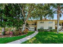Inviting condo exterior with lush landscaping, walkway and a view of the two-story building at 1729 Seascape Cir # 102, Tarpon Springs, FL 34689