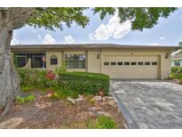 Charming single-story home with a well-manicured lawn, tidy shrubbery, and a driveway leading to an attached two-car garage at 2609 Lancaster Dr, Sun City Center, FL 33573