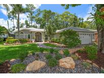 Charming single-story home featuring meticulously maintained landscaping, mature trees, and a welcoming front entrance at 3273 Tanglewood Trl, Palm Harbor, FL 34685