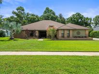 Charming brick home with mature landscaping and a well-manicured lawn at 3305 Westmoreland Dr, Tampa, FL 33618