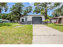 Charming single-story home featuring a convenient attached garage and fresh landscaping at 5847 Harrison St, New Port Richey, FL 34653