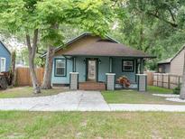 Charming bungalow with blue siding, inviting front porch, and lush landscaping at 708 E Patterson St, Tampa, FL 33604