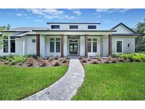 Beautiful single-Gathering home featuring a manicured lawn and inviting column-lined front porch at 937 Old Welcome Rd, Lithia, FL 33547