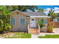 Charming single-story home featuring a beige stucco exterior and a well-manicured front yard at 1011 Newton S Ave, St Petersburg, FL 33705