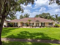 Charming ranch-style home with a lush green lawn, mature trees, and inviting curb appeal at 10502 Lake Williams Dr, Odessa, FL 33556