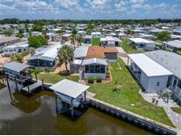 Aerial view of waterfront home with boat lift and lush landscaping in a vibrant community at 108 W Saint Annes Cir, Apollo Beach, FL 33572