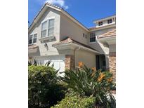 Charming two-story home featuring stone accents, a two-car garage, and lush landscaping at 14618 Mirabelle Vista Cir, Tampa, FL 33626