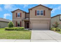 Charming two-story home featuring a well-maintained lawn and a two-car garage at 1613 Cabbage Key Dr, Ruskin, FL 33570