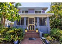 Charming home featuring a yellow screen door and vibrant potted plants flanking the steps at 1822 1St Se St, St Petersburg, FL 33705