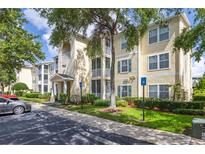 Three-story condo building with balconies, green shrubs, and a parking lot in front at 18439 Bridle Club Dr # 18439, Tampa, FL 33647