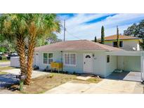 Charming single-story home with light blue siding, a brown roof and a well-manicured front yard at 1887 Springtime Ave, Clearwater, FL 33755