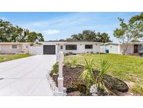 Charming home with a well-maintained front yard, grey garage door, and modern mailbox at 3381 19Th Sw Pl, Largo, FL 33774